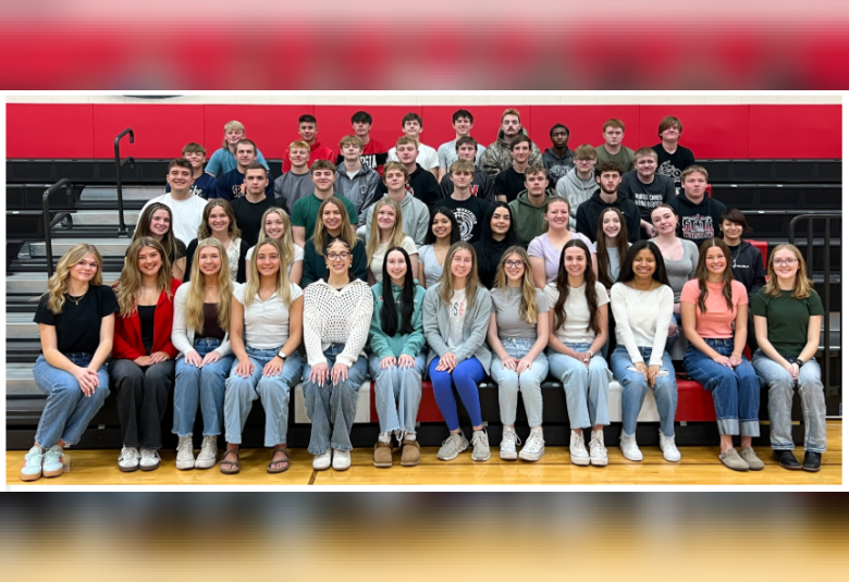 Group photo of the class, sitting on several rows of bleachers.