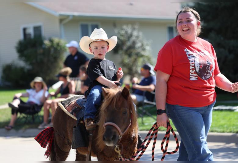 Hannah Welch helps lead her son, Oaklen Rush, and his horse through the homecoming parade on Friday.
