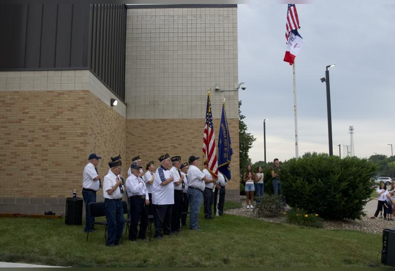 Legion members and students stand and salute the American flag as it was raised to mark the start of the new school year.
