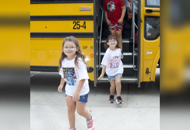 Sisters, Zoie and Lilliana Hansen are all smiles as they arrive at school and get off the bus.