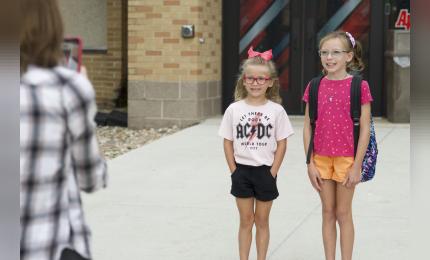 Members of the Akron Legion Post 186, as well as A-W students line the sidewalk and welcome students back for the first day.